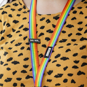 rainbow lanyard with black enamel pronoun pin